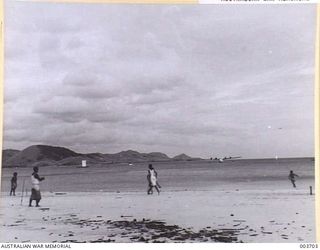 PORT MORESBY - NATIVES PLAYING "CRICKET" ON ELA BEACH. RAAF SURVEY FLIGHT. (NEGATIVE BY N. TRACY)