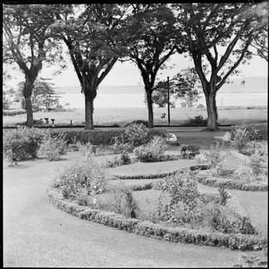 View across the Chinnery garden towards the harbour with two women walking past, Malaguna Road, Rabaul, New Guinea, ca. 1936 / Sarah Chinnery