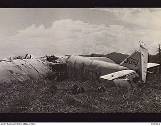 LAE, NEW GUINEA. 1943-10-04. A WRECKED FORD PEACE-TIME TRANSPORT AIRCRAFT ON THE AIRSTRIP AT NO. 4 AUSTRALIAN BASE AREA, NEW GUINEA FORCE