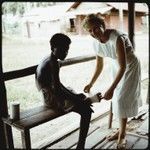 European woman doctoring foot of boy