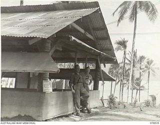 JACQUINOT BAY, NEW BRITAIN. 1945-02-04. NX103846 LIEUTENANT A.P. MORRIS (1) AND NX174918 SERGEANT R.F. MURRAY (2) OF THE ARMY AMENITIES SERVICE, 5TH BASE SUB AREA OUTSIDE THE UNIT AMENITIES HUT