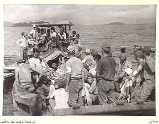 MOILA POINT, BOUGAINVILLE. 1945-09-28. A JAPANESE BARGE LOADED WITH TROOPS AND STORES FROM TONOLEI HARBOUR MOVING TO AN ASSEMBLY POINT AT KAHILI FOR EMBARKATION TO THE CONCENTRATION CAMP ON FAURO ..
