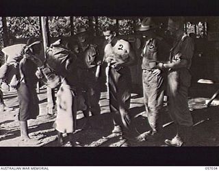 NADZAB, NEW GUINEA. 1943-09-19. AUSTRALIAN OFFICERS OF THE 2/4TH AUSTRALIAN FIELD AMBULANCE MAIN DRESSING STATION, 7TH AUSTRALIAN DIVISION, TALKING WITH TWO NATIVES. LEFT TO RIGHT: NX454 LIEUTENANT ..