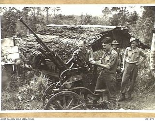 PALANKO, NEW GUINEA. 1943-12. OFFICERS OF THE 26TH AUSTRALIAN INFANTRY BRIGADE INSPECTING A CAPTURED JAPANESE 20MM DUAL PURPOSE ANTI-AIRCRAFT AND ANTI-TANK GUN. SHOWN ARE: NX12355 CAPTAIN H. B. ..