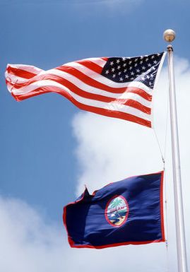 The American flag flies above the flag of Guam