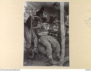 YAMIL SECTOR, NEW GUINEA. 1945-08-01. CAPTAIN J.V. WILKINSON, DENTAL OFFICER, B SECTION, 2/4 DENTAL UNIT (1), GIVING FRONT LINE DENTAL TREATMENT TO PRIVATE J.F. PARKER, 2/6 INFANTRY BATTALION (2). ..