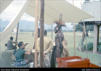Man in traditional dress collecting ballot paper