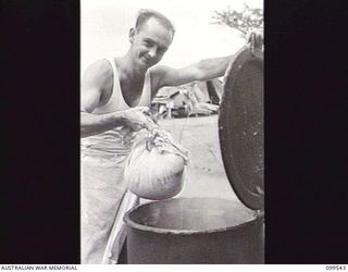 RABAUL, NEW BRITAIN, 1945-12-25. PRIVATE H. C. MANN, COOK, TAKING A CHRISTMAS PUDDING FROM THE COPPER AT HEADQUARTERS 37/52ND INFANTRY BATTALION