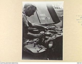 CAPE PUS, WEWAK AREA, NEW GUINEA, 1945-09-07. DRIVER S. BATES, TRANSPORT PERSONNEL, 2/1 INFANTRY BATTALION, WORKING UNDER THE BONNET OF HIS JEEP