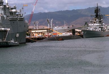 The Third Fleet flagship USS CORONADO (AGF-11), left, the nuclear-powered strategic missile submarine USS OHIO (SSBN-726), center, and the guided missile cruiser USS WORDEN (CG-18) lie tied up at the naval station.