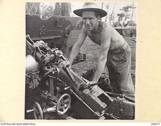 CAPE PUS, WEWAK AREA, NEW GUINEA. 1945-09-07. GUNNER F. MCBRIDE, 2/3 FIELD REGIMENT, ROYAL AUSTRALIAN ARTILLERY, MAINTENANCING HIS GUN BEFORE ITS RETURN TO ORDNANCE