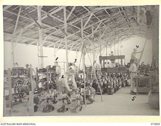 LAE, NEW GUINEA. 1944-06-09. A GENERAL VIEW OF THE ENGINE RECONDITIONING SHOP AT THE 2/7TH ADVANCED WORKSHOP. IDENTIFIED PERSONNEL ARE:- NX39382 CRAFTSMAN G R KUHNELL (1); NX67573 CRAFTSMAN T W E ..