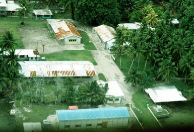 A view of buildings on a Micronesian island as seen from the back of a 374th Tactical Airlift Wing C-130 Hercules aircraft. The plane will be airdropping containers onto the island during Christmas Drop, an annual, humanitarian airdrop providing aid to needy islanders throughout Micronesia during the holiday season