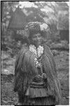 New mother wearing long fiber shawl, fiber skirts, flower garland, skirt valuable on head, and paint on face