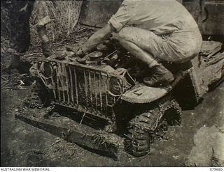 Oro Bay, New Guinea. 1943-05. A jeep bogged in mud to its axles following heavy rain, near the 10th Field Ambulance, Australian Army Medical Corps