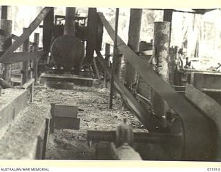 LAE, NEW GUINEA. 1944-03-30. A STEAM ENGINE WITH BELTS AND SHAFTINGS GIVING POWER TO DRIVING ROLLERS AT THE BENCH SAW, 59TH CORPS FIELD PARK COMPANY. THE 16 HORSE POWER BOILER AND ENGINE WERE ..