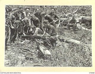 BOUGAINVILLE ISLAND. 1945-01-16. MEMBERS OF "D" COMPANY AND "B" COMPANY, 47TH INFANTRY BATTALION EXAMINING A JAPANESE TYPE 92 "WOODPECKER" MACHINE GUN AND OTHER ARMS CAPTURED BY "B" COMPANY IN AN ..