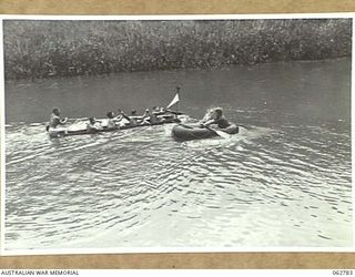 KUBA LAKE, RAMU VALLEY, NEW GUINEA. 1943-12-25. COMPETITORS IN THE BOAT RACE APPROACHING THE TURN AT THE CHRISTMAS CARNIVAL AND REGATTA ORGANISED BY MEMBERS OF THE 2/14TH INFANTRY BATTALION, 7TH ..