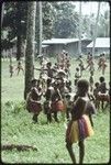 Dance: children wearing decorative fiber skirts and other adornments, gathering for dance