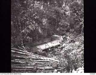 DONADABU, NEW GUINEA. 1943-10-07. WRECKED ARMY TRUCK WHICH CRASHED DOWN THIS GORGE ON THE DONADABU ROAD