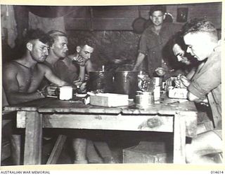 1943-04-08. NEW GUINEA. AUSTRALIAN TROOPS AT WAU EATING IN AN UNDERGROUND MESS ROOM. (NEGATIVE BY F. BAGNALL)