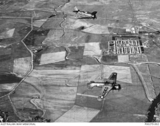 Two Wirraway aircraft of No. 4 Squadron, RAAF, in mirror formation over the Causeway. A20-160 was subsequently shot down by ground fire whilst on a tactical reconnaissance mission over Buna, New ..