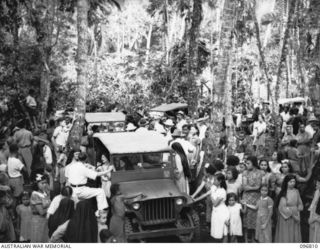 Ramale Mission, Kokopa Area, New Britain. Farewell scene as ten of a group of 300 white former internees prepare to leave Ramale Mission by jeep for the five mile trip to the beach for evacuation ..