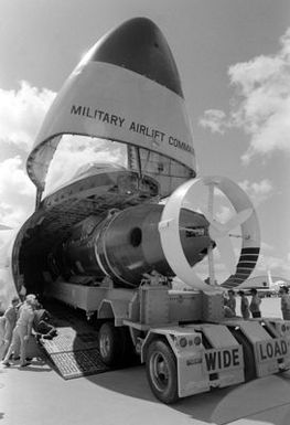 The trailer carrying the deep submergence rescue vehicle AVALON (DSRV-2) backs down the ramp of an Air Force C-5A Galaxy aircraft from the 60th Military Airlift Wing (MAW-60). The AVALON is being used in a fly-away exercise to train personnel in the handling and operation of the vehicle