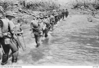 DOYABIE AREA, BOUGAINVILLE ISLAND. 1944-11-23. TROOPS OF THE 9TH INFANTRY BATTALION FORDING THE LARUMA RIVER AT THE END OF THE NUMA NUMA TRAIL AS THEY MOVE FORWARD TO TAKE OVER POSITIONS OCCUPIED ..