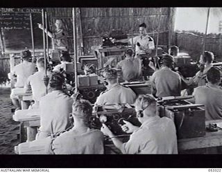 SOGERI VALLEY, NEW GUINEA. 1943-06-26. STUDENTS INSIDE A CLASSROOM OF THE NEW GUINEA FORCE SCHOOL OF SIGNALS ARE BEING INSTRUCTED IN THE TUNING OF THE NO. 11 SET (AUSTRALIAN) TRANSMITTER. ..