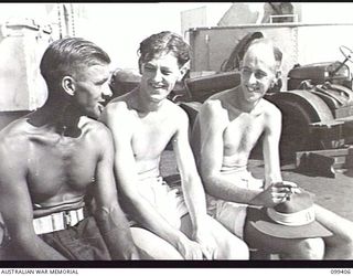 WEWAK HARBOUR, NEW GUINEA, 1945-12-13. APPROXIMATELY 2,200 MEMBERS OF 6 DIVISION EMBARKED ON THE AIRCRAFT CARRIER HMS IMPLACABLE FOR RETURN TO AUSTRALIA. SHOWN, CORPORAL J. F. MASON (1), AND STAFF ..