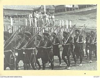 BISIATABU, NEW GUINEA. 1944-04-19. THE ROYAL PAPUAN CONSTABULARY BAND MARCH PAST THE SALUTING BASE AT THE ROYAL PAPUAN CONSTABULARY TRAINING DEPOT. MAJOR-GENERAL B.M. MORRIS, DSO, GENERAL OFFICER ..