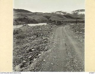 WAU - LAE ROAD, NEW GUINEA, 1944-02-26. ABOUT 4 MILES OF GOOD ROAD APPROXIMATELY HALF A MILE ON THE NORTH SIDE OF THE BULLOLO - WATUT RIVER JUNCTION, RUNNING ACROSS CAST OFF GOLD DREDGE TAILINGS. ..