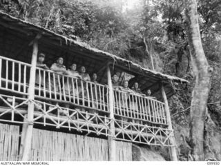 RABAUL, NEW BRITAIN, 1945-12-25. LIEUTENANT-COLONEL WOO YIEN, COMMANDING CHINESE ARMY TROOPS IN NEW BRITAIN, WITH AUSTRALIAN AND CHINESE OFFICERS ON THE BALCONY OF THE OFFICERS MESS AT THE CHINESE ..