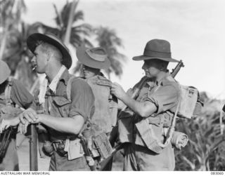 BABIANG, NEW GUINEA. 1944-11-09. TROOPER E.C. ABSOLOM, (1), HAS HIS GEAR CHECKED BY CAPTAIN L.T. SHORT (2), 2/10 COMMANDO SQUADRON, BEFORE LEAVING ON PATROL. OWING TO INTENSE HEAT, LITTLE IS ..