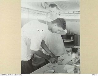 LAE, NEW GUINEA. 1944-09-18. NX76594 MAJOR H. THOMPSON, DENTAL OFFICER, WORKING IN THIS SURGERY AT HEADQUARTERS NEW GUINEA FORCE