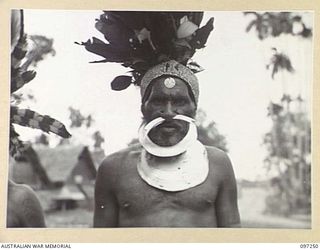 LAE, NEW GUINEA. 1945-09-07. ONE OF THE CHIMBU CHIEFS WHO ARRIVED AT HEADQUARTERS FIRST ARMY WITH AN AUSTRALIAN NEW GUINEA ADMINISTRATIVE UNIT ATTENDANT. THE CHIEFS ARRIVED TO PAY THEIR RESPECTS TO ..