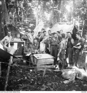 FINSCHHAFEN AREA, NEW GUINEA. 1943-11-13. MEMBERS OF HEADQUARTERS, 9TH AUSTRALIAN DIVISION DRAWING THE MELBOURNE CUP SWEEP, OUTSIDE THE CAMP COMMANDANT'S OFFICE
