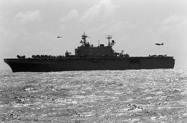 An AV-8B Harrier II aircraft hovers over the stern of the amphibious assault ship USS SAIPAN (LHA-2) during Fleet Ex 1-90.