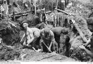 TOROKINA AREA, BOUGAINVILLE ISLAND. 1944-11-29. QX50003 PRIVATE M.S. OVERNDEN, VICKERS GUNNER (1) KEEPING A SHARP LOOKOUT FOR THE ENEMY WHILE HIS COMRADES OF D COMPANY, 9TH INFANTRY BATTALION ..