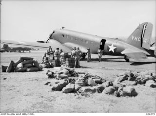 PAPUA. 1942-08-19. LOADING DOUGLAS C47 PLANES WITH SUPPLIES FOR TROOPS IN THE FORWARD AREA. FOR TROOPS NEAR KOKODA, SUPPLIES ARE DROPPED FROM THE PLANES. THE GROUND TROOPS HAVE NICKNAMED THESE ..