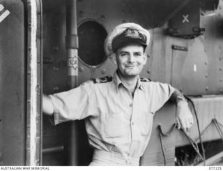 MADANG AREA, NEW GUINEA. 1944-11-08. PAY LIEUTENANT J. CASEY, ROYAL AUSTRALIAN NAVAL RESERVE, ABOARD THE HMAS "BARCOO" AS THE VESSEL CRUISES ALONG THE COAST