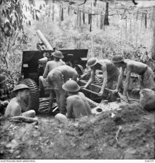 PAPUA. 1942-09. A GUN CREW OF THE 14TH FIELD REGIMENT (MILITIA), ROYAL AUSTRALIAN ARTILLERY, WITH THEIR 25-POUNDER GUN IN ACTION POSITION IN THE OWEN STANLEY RANGE. IDENTIFIED ARE; 2ND FROM LEFT, ..