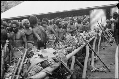 Group of men at a laden trestle table, Boong, native market, Rabaul, New Guinea, ca. 1929 / Sarah Chinnery