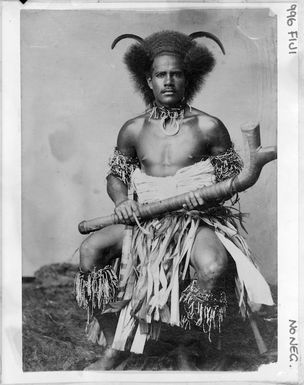 Unidentified Fijian man in ceremonial clothing, holding a club