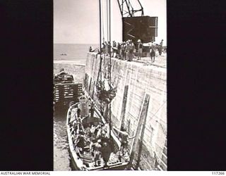 NAURU ISLAND. 1945-09-14. TROOPS OF THE 31/51ST AUSTRALIAN INFANTRY BATTALION UNLOADING SUPPLIES AT THE BRITISH PHOSPHATE COMMISSION WHARF
