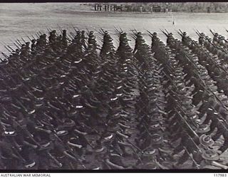 TOROKINA, BOUGAINVILLE. 1945-10-29. PERSONNEL OF 47TH INFANTRY BATTALION MOVING TOWARDS THE SALUTING BASE WHERE THE COMMANDER IN CHIEF, AUSTRALIAN MILITARY FORCES, IS TAKING THE SALUTE DURING A ..