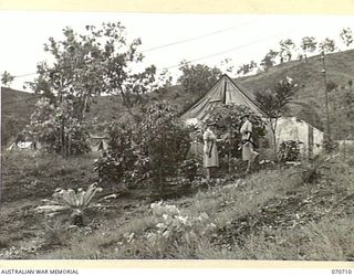 SEVENTEEN MILE, PORT MORESBY, PAPUA, NEW GUINEA, 1944-03-01. QFX19063 SISTER G.E. BROWN (1), WITH QFX19056 MATRON E.R. MCGHIE (2), DISCUSSING THE GROWTH OF PLANTS OUTSIDE THE MATRON'S TENT AT THE ..