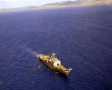 An aerial starboard bow view of the tank landing ship USS CAYUGA (LST-1186) underway