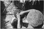 Pig festival, wig ritual, Tsembagal: man's hair is pulled over wig frame, overhead view